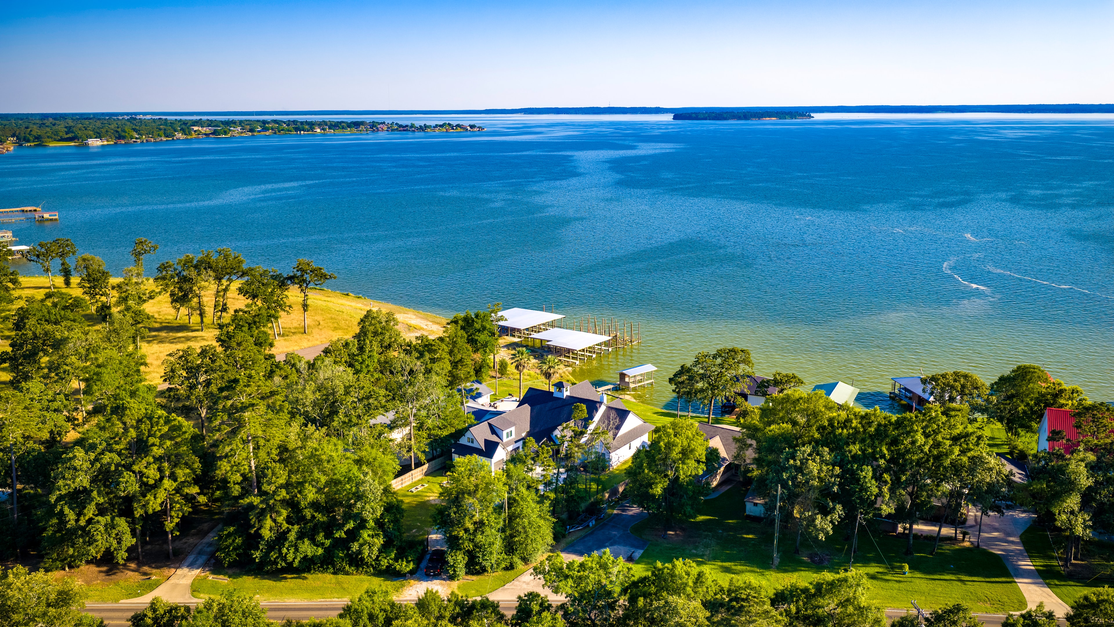 Aerial view of lake house and surrounding property