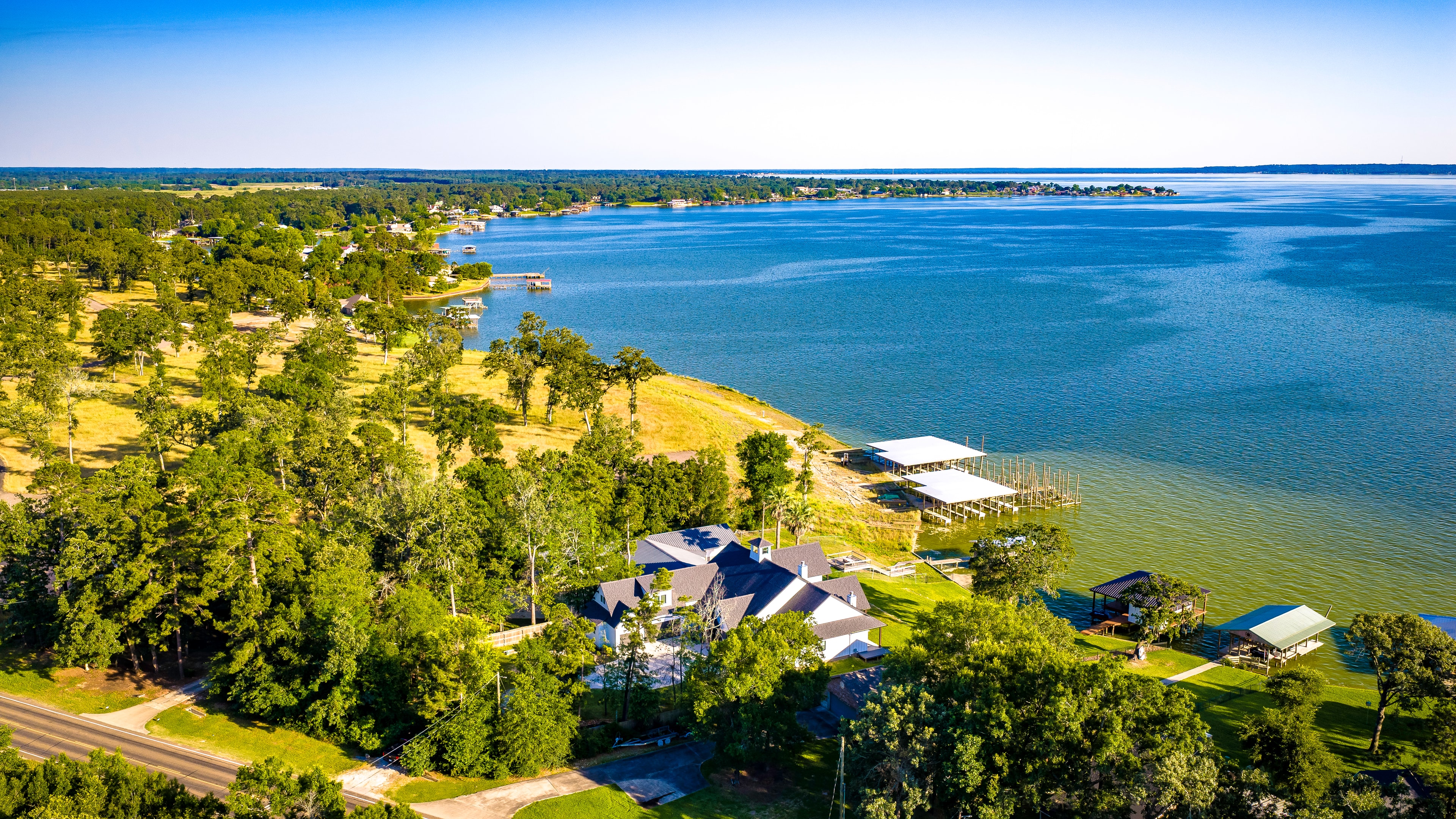 Lakefront home aerial view over blue water