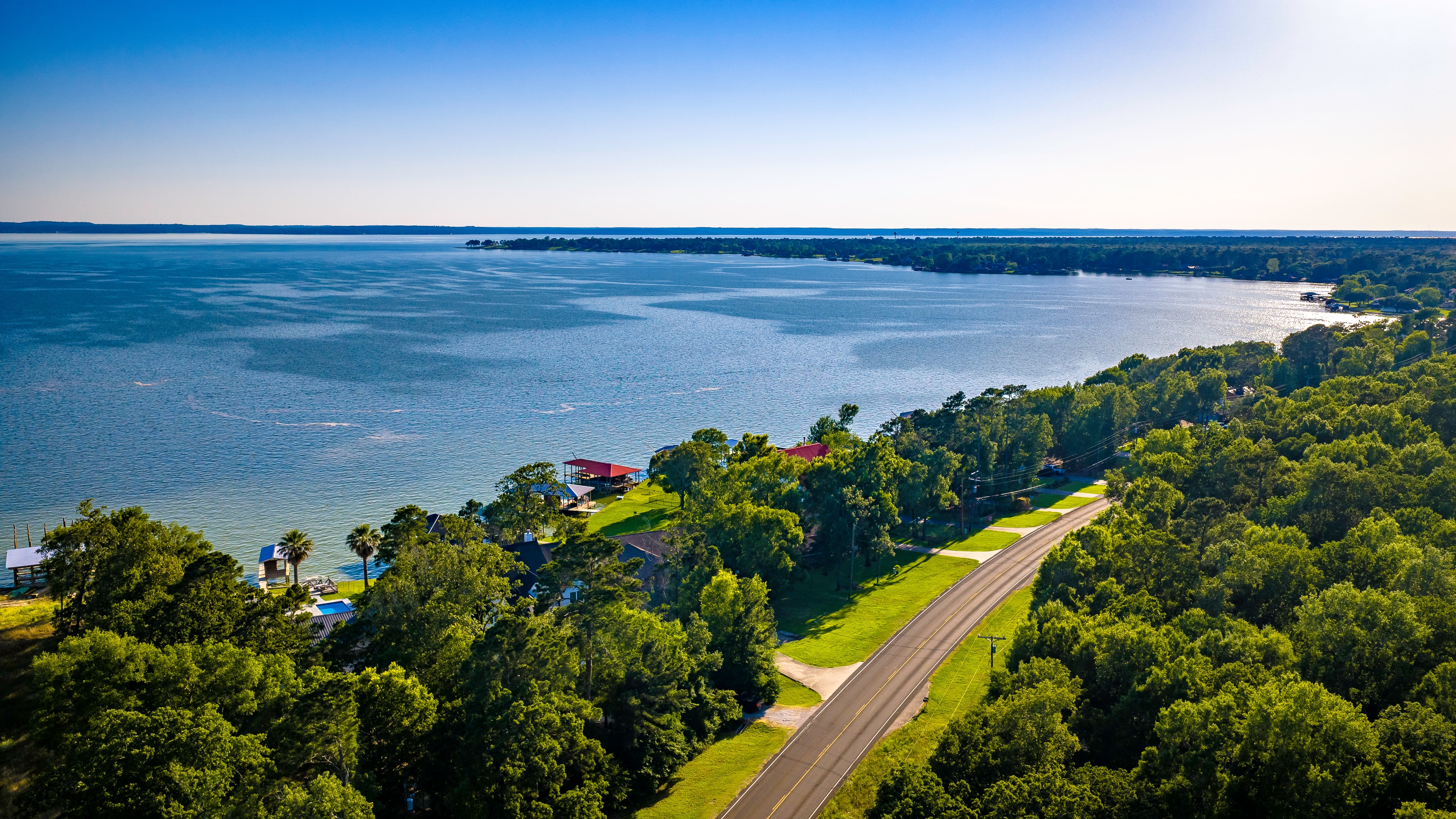Aerial road through forest toward Lake Livingston