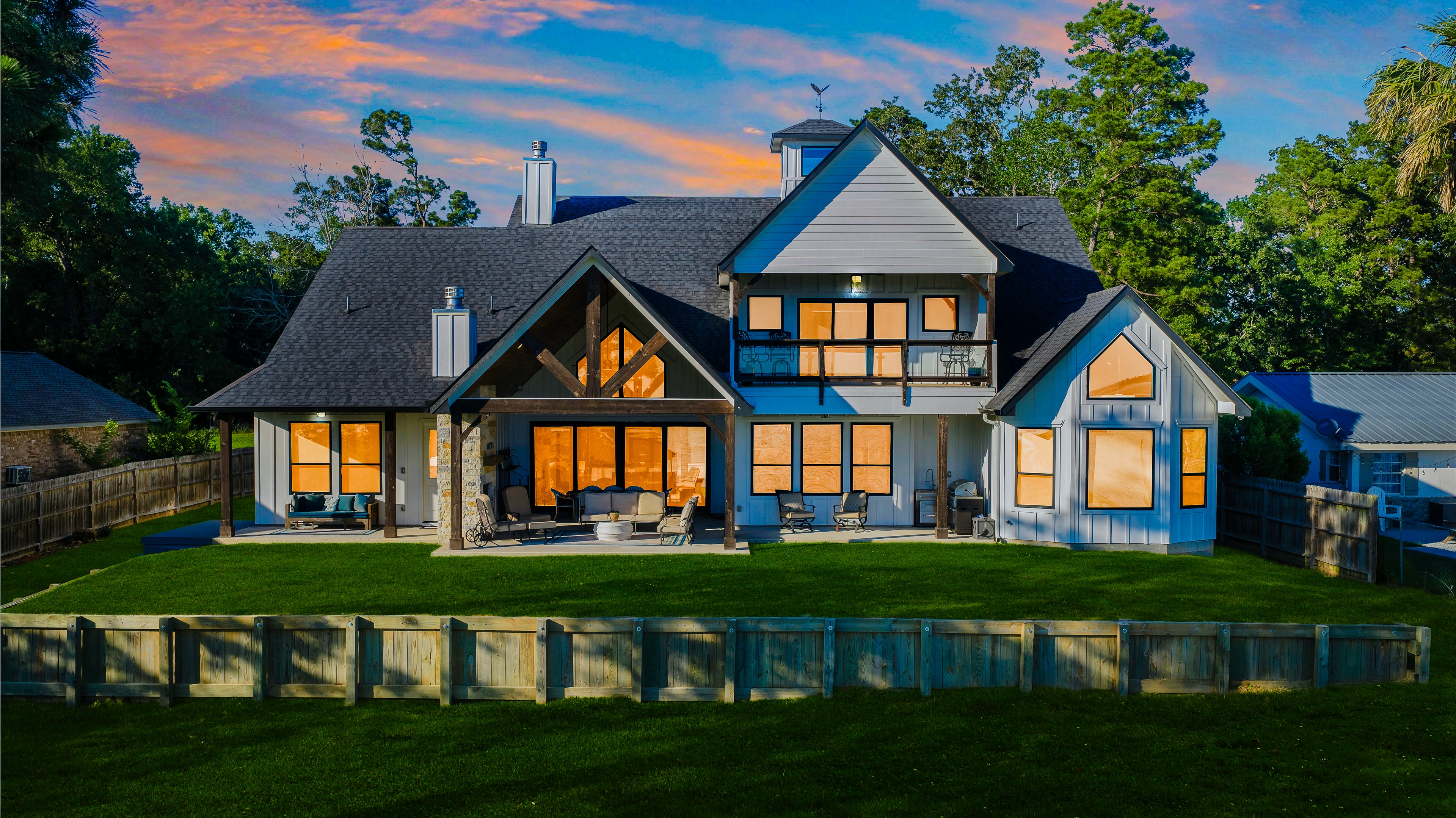 Lake house glowing at dusk with water views