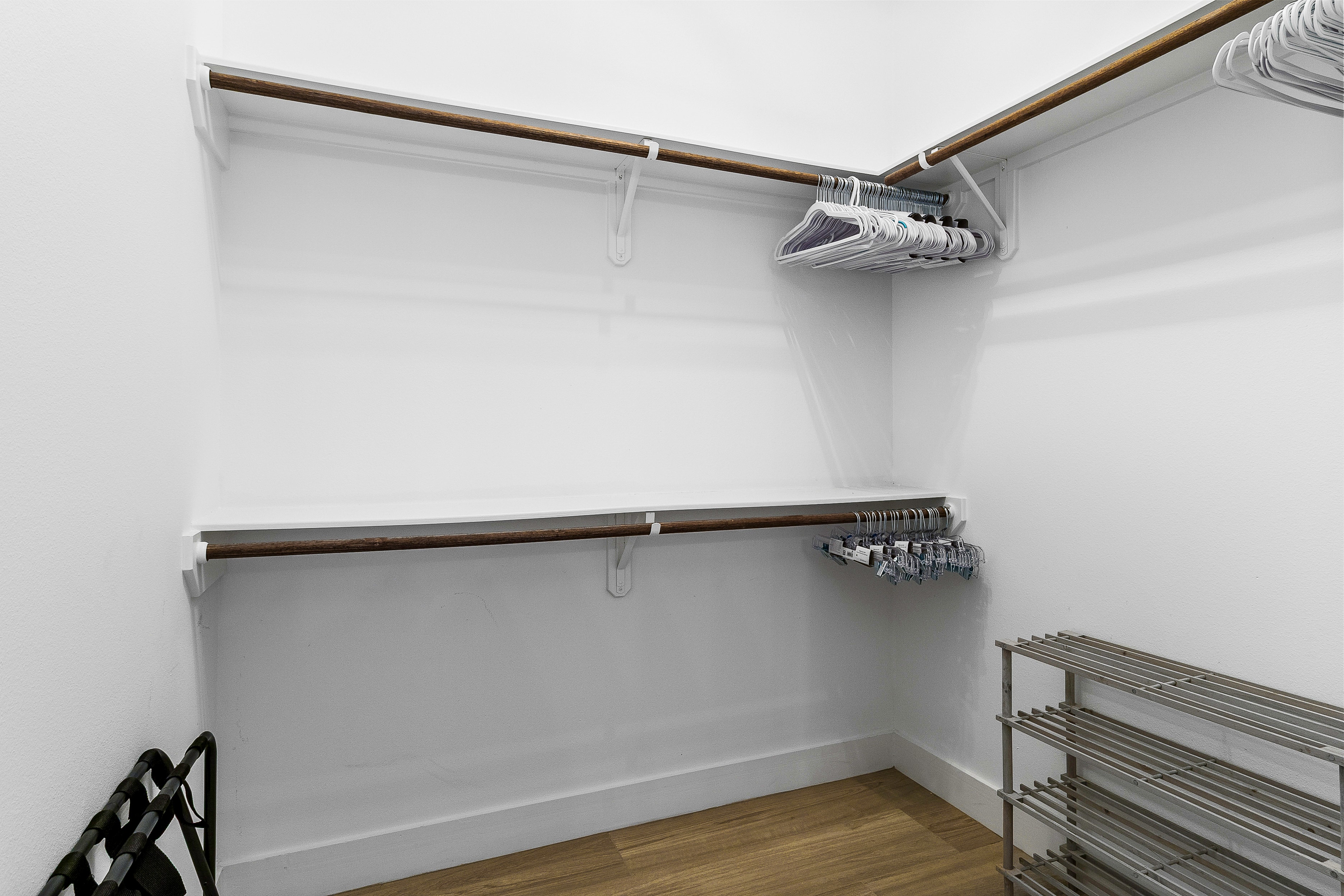 Walk-in closet with wooden rods and hangers