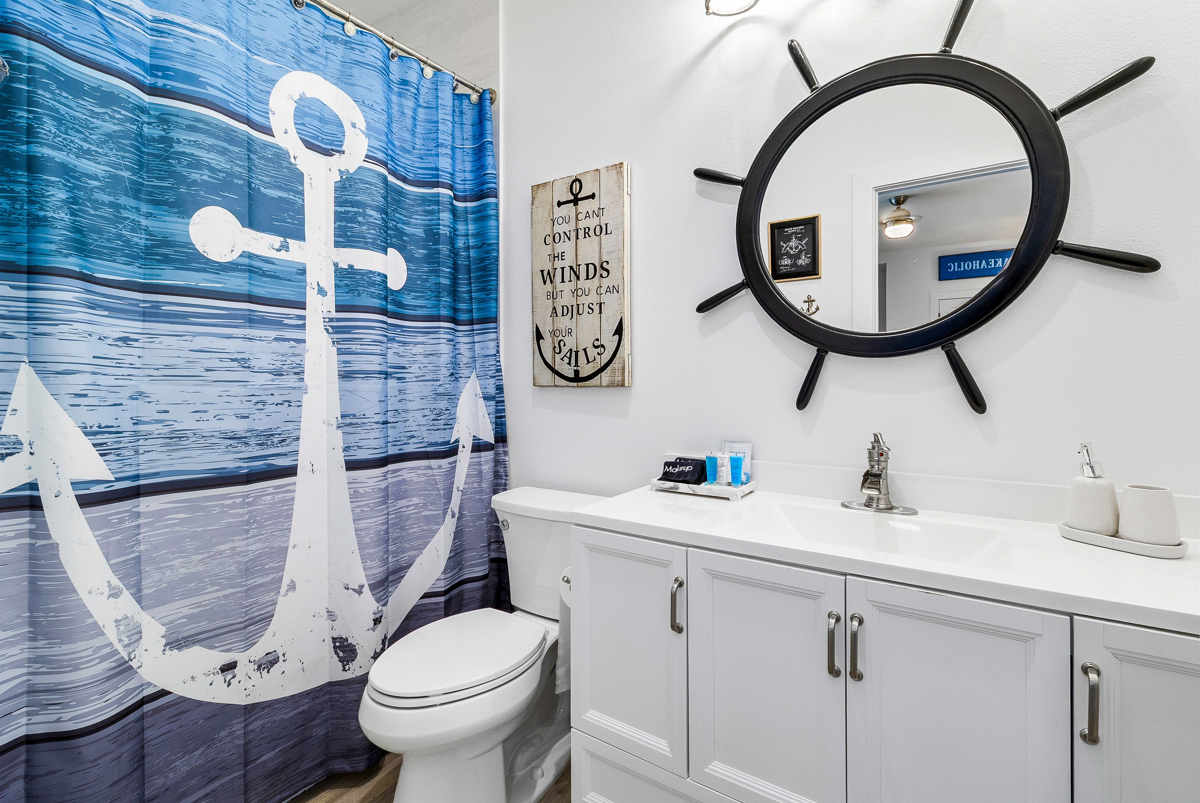 Nautical bathroom with ship wheel mirror