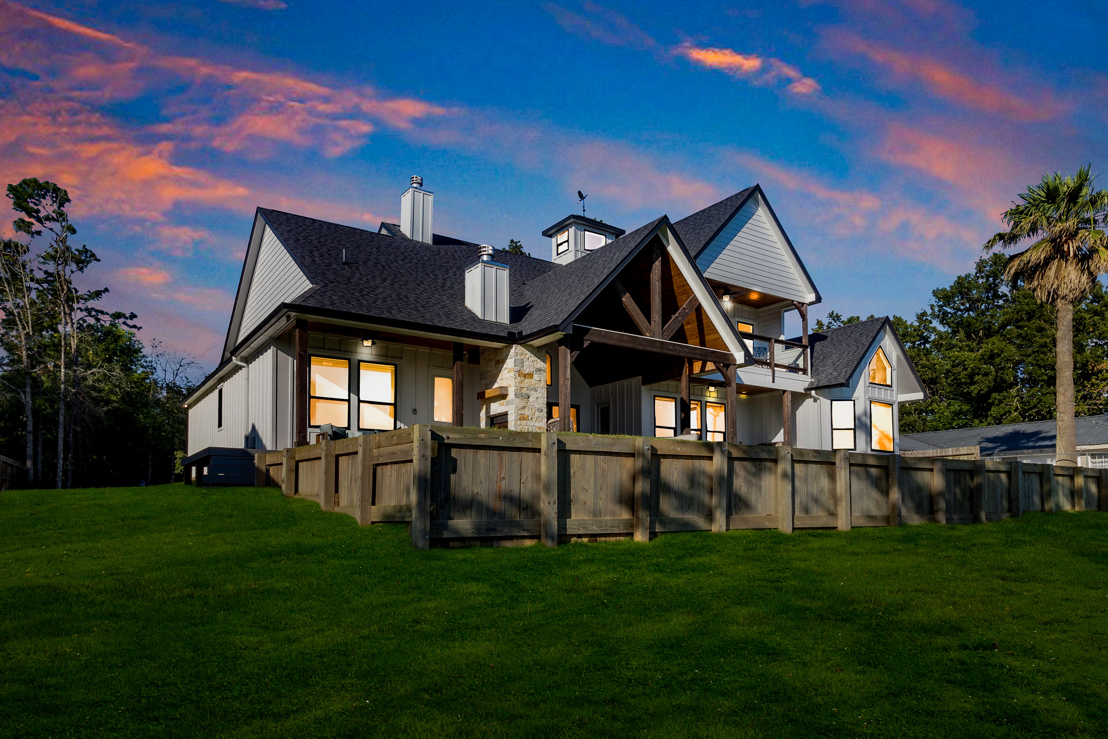 Lake house with illuminated windows at dusk
