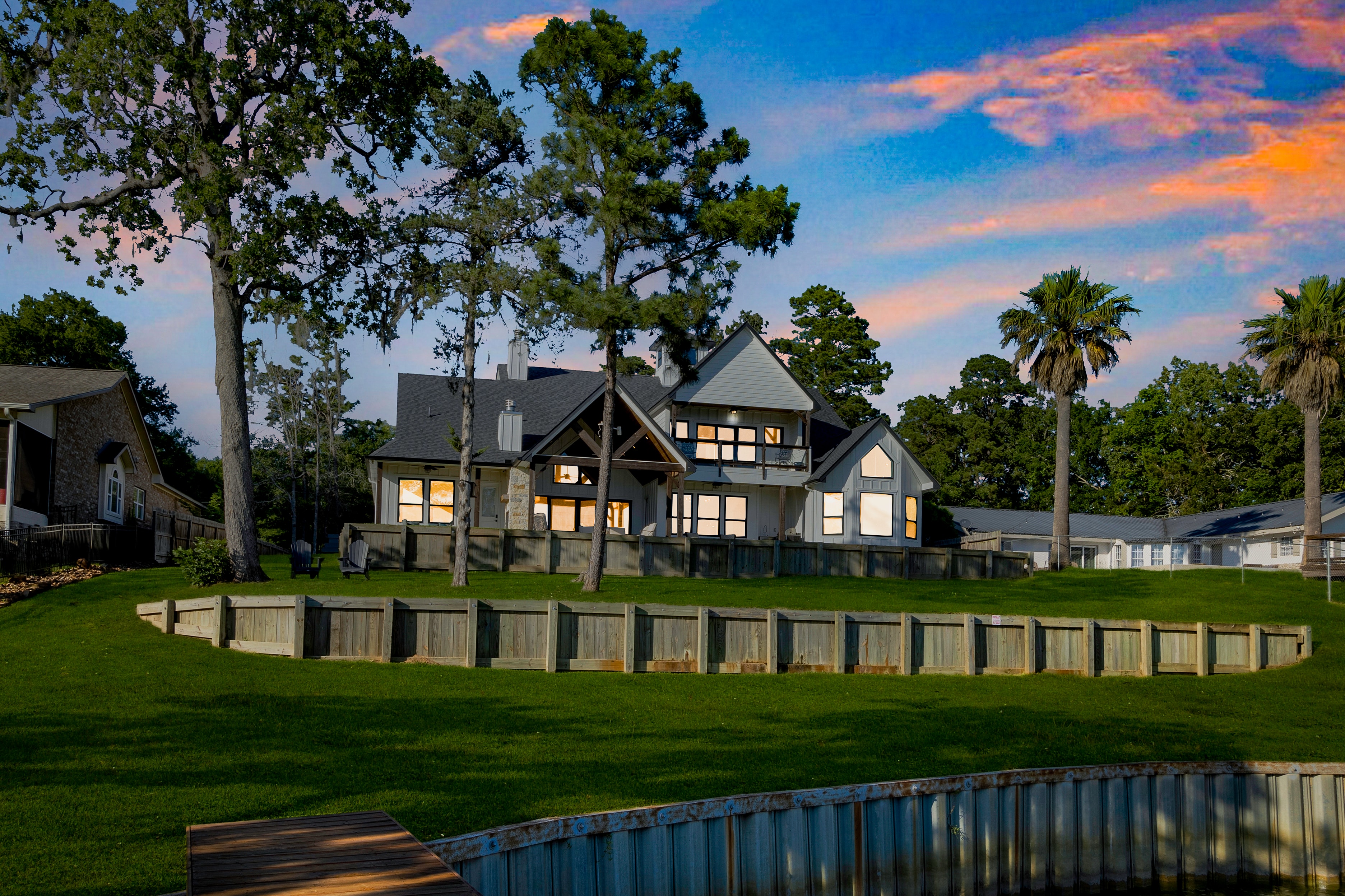 Waterfront home at twilight with trees
